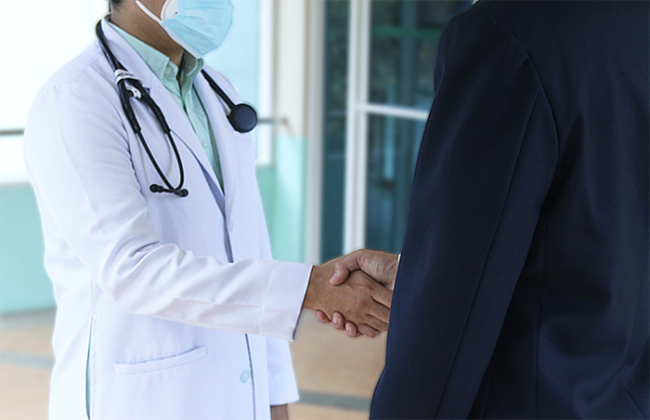 medico stretta mano camice covid